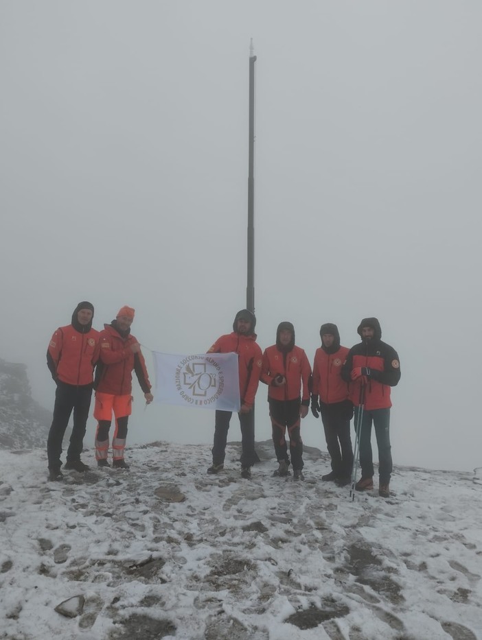 La bandiera del 70° anniversario della nascita del Soccorso Alpino issata sulle croci del Cistella, Zeda e Massone